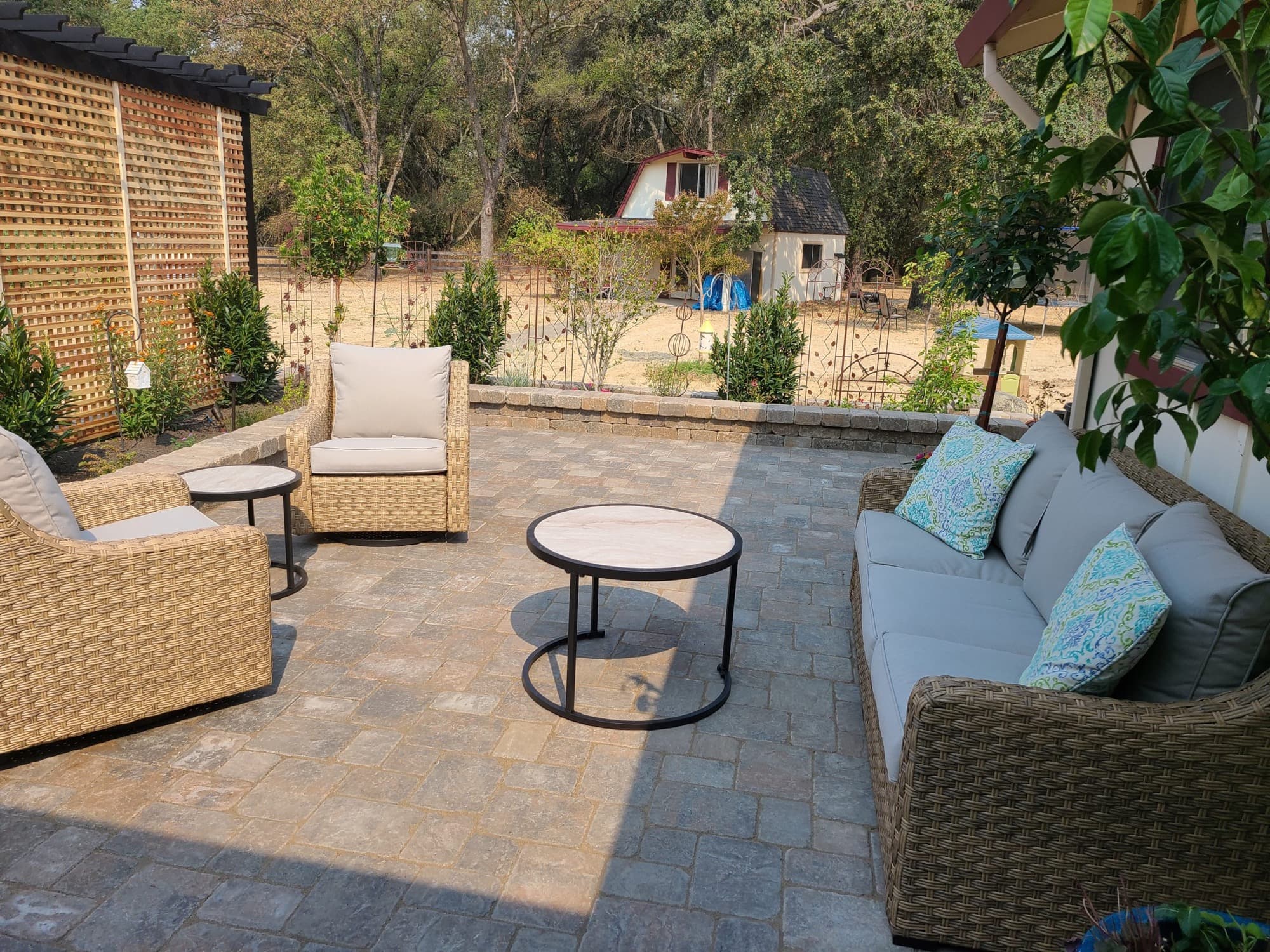 Paver patio lounge with a wood lattice privacy screen built by Holt Landscape