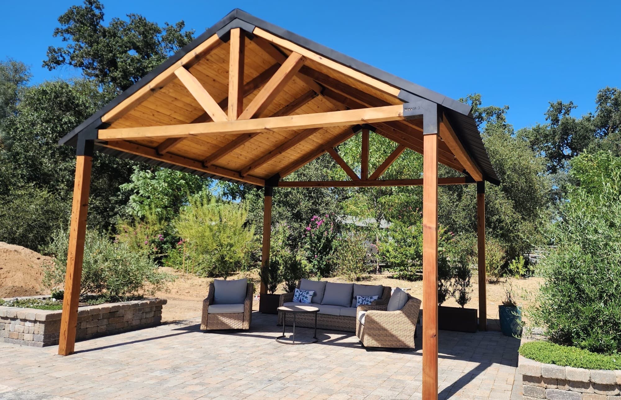 Custom timber-frame patio cover shading a paver patio with lounge seating